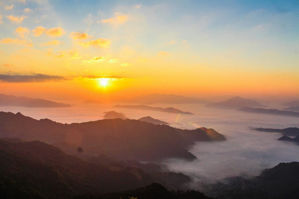 Stunning sunrise scene with mist-covered valleys and majestic mountain landscape.